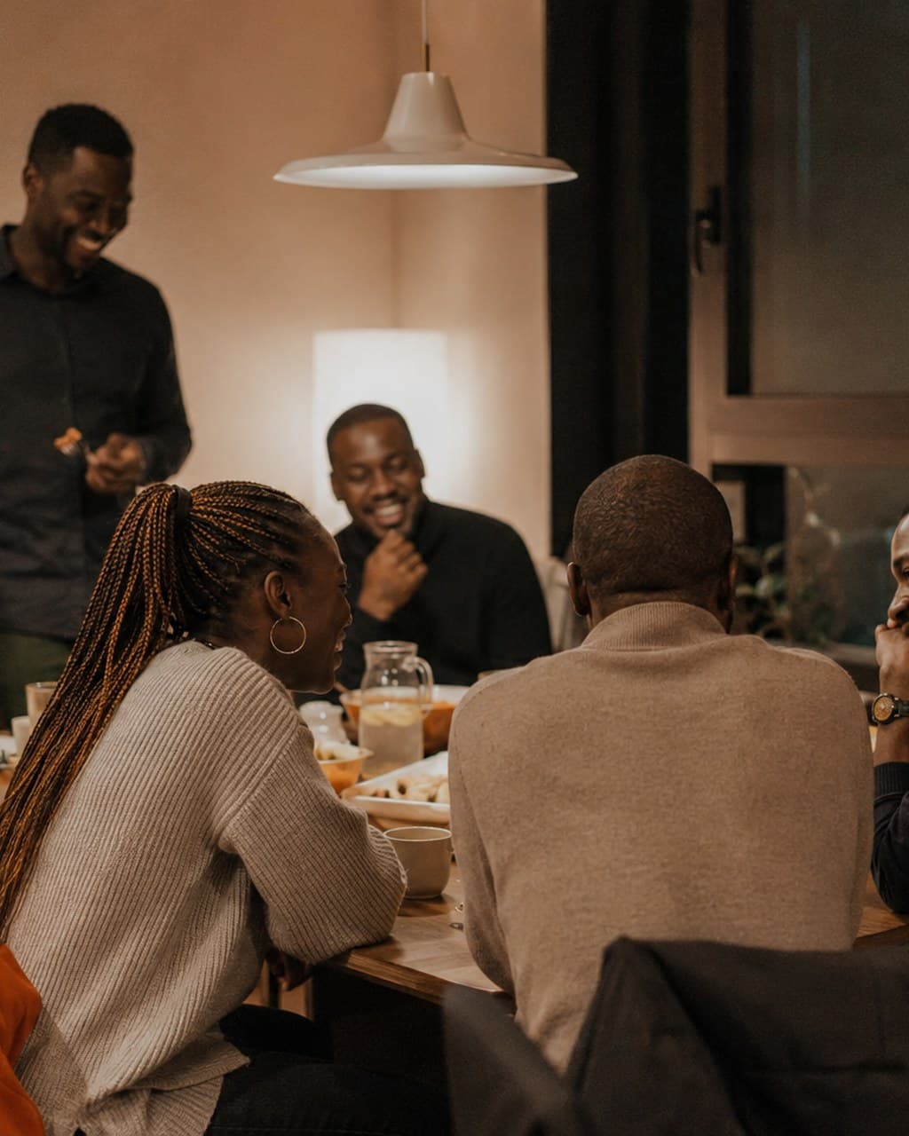 A diaspora community dinner: friends laughing around one table, a long way from home